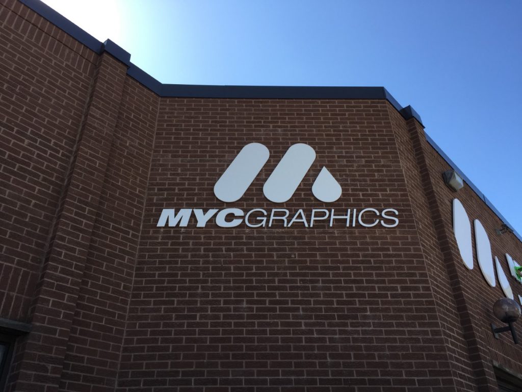 Custom signs in Mississauga – MYC Graphics metal logo and lettering on a brick building