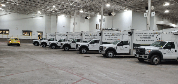 Fleet of commercial vehicles branded with fleet graphics to be used for fleet marketing parked in a warehouse